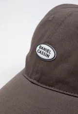 Gorro verde con visera y logo bordado en el frente.