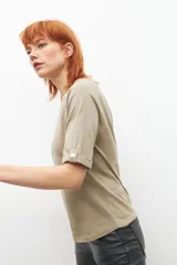 Remera verde oliva de manga ranglán con botón en el puño.