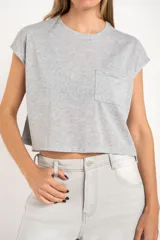 Remera gris de algodón con poliéster, corte crop, mangas cortas y bolsillo en el pecho.