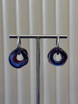 Aros de argolla en plata 925 con dijes circulares de vidrio soplado en tonos azul y bordó.