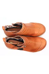 Botin de cuero negro con suela de goma tipo burbuja, diseño clásico con hebilla metálica lateral y elásticos para mayor ajuste.