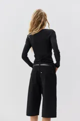 Remera negra de manga larga, corte ajustado al cuerpo, con cuello redondo y tejido de punto acanalado.