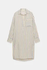 Vestido midi estilo camisero de Zara Woman Collection, confeccionado en lino, con estampado de rayas verticales azules sobre fondo beige. Cuenta con cuello solapa, escote en V con botonadura parcial, manga larga con puños abotonados, un bolsillo de plastrón en el pecho y bajo redondeado.