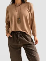Sweater de punto con diseño oversize y corte relajado, confeccionado en una mezcla de viscosa y lana. Presenta cuello redondo, mangas largas y un largo asimétrico con la parte trasera más extensa.