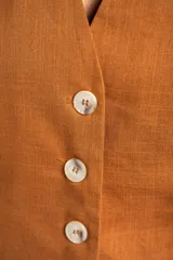 Chaleco de corte sastre con escote en V y cierre frontal de botones. Presenta un diseño sin mangas, entallado al cuerpo, confeccionado en una mezcla de lino y viscosa.