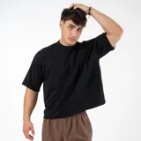 Remera negra de algodón, corte cuadrado y holgado, estilo boxy fit, cuello redondo y mangas cortas.