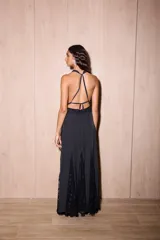 Vestido largo de seda color negro con estampado de lunares blancos. Presenta una silueta fluida, escote en V profundo con detalles de encaje y espalda descubierta con tiras cruzadas.