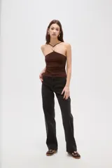 Top de cuello halter con detalle de aro metálico en el centro, confeccionado en tejido al cuerpo.