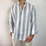 Camisa de lino a rayas verticales en tonos gris y blanco, con cuello mao y cierre frontal de botones.