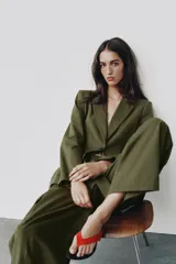 Blazer verde militar entallado con cuello de solapa, manga larga, cierre frontal de un botón y bolsillos con solapa.