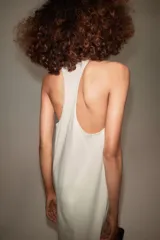 Vestido largo de algodón color blanco, con escote redondo, diseño sin mangas de corte nadador y bajo evasé.