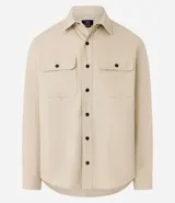Camisa de manga larga confeccionada en sarga de algodón color verde menta, con cuello inglés y cierre frontal de botones negros. Presenta dos bolsillos de parche con solapa en el pecho y puños con botones.