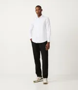 Camisa blanca de algodón, corte slim fit, manga larga y cuello clásico.