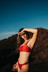 Conjunto de bikini rojo con hebillas metálicas plateadas y bombacha colaless.