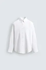 Camisa de corte regular fit confeccionada en tejido de algodón con efecto lavado. Presenta cuello abotonado, manga larga con puños abotonados, bolsillo en el pecho y cierre frontal con botones.