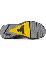 Championes de entrenamiento Under Armour Project Rock BSR 5, diseñados para estabilidad y flexibilidad. Presentan una parte superior de malla transpirable en color gris con detalles en negro y amarillo, mediasuela Charged Cushioning para amortiguación reactiva y tecnología UA TriBase para mayor contacto con el suelo.