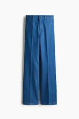 Jean de denim azul de tiro alto, con corte recto holgado, pliegues frontales y cierre con botón y cremallera.