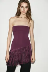 Top bandeau blanco con escote palabra de honor y bajo asimétrico con flecos.