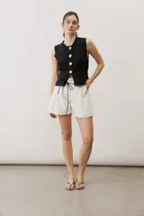 Short blanco de tiro alto, confeccionado en lino, con bolsillos laterales y cordón ajustable en la cintura.