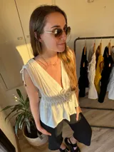 Musculosa blanca de tusor con breteles finos y escote en V con lazo ajustable.