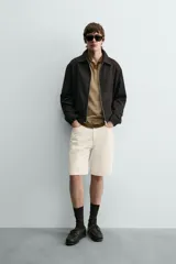 Sobrecamisa regular fit color gris oscuro, confeccionada en tejido con viscosa. Presenta cuello solapa, manga larga con puño abotonado, bolsillos de vivo en la cadera y cierre frontal con cremallera.