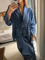 Pollera larga de jean fino color azul, con diseño amplio, elástico en la cintura y bolsillos delanteros grandes. Cuenta con pinzas y superposiciones de tela en los laterales que aportan volumen y movimiento.