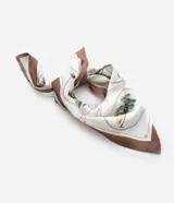 Pañuelo de poliéster satinado, color crema, con estampa botánica en tonos verdes y marrones, y bordes en color marrón oscuro.