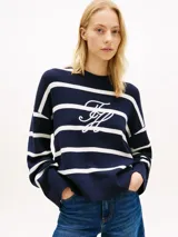 Sweater amplio de punto Tommy Hilfiger confeccionado en puro algodón peinado, de diseño a rayas horizontales azul marino y blancas, con cuello redondo y hombros caídos. Presenta el logo bordado en fuente Script en la parte delantera.