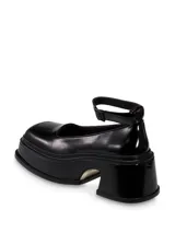 Zapato de charol negro con correa al tobillo, punta cuadrada y plataforma con taco ancho.