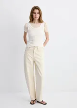 Jeans de corte holgado y tiro medio color beige claro, con diseño de pernera ancha y bolsillos clásicos.