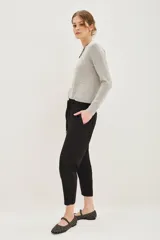 Pantalon estilo babucha color mostaza, con cintura elástica y cordón de ajuste, bolsillos diagonales frontales y terminaciones ajustadas en los tobillos.