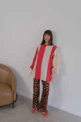 Buzo de viscosa con diseño a rayas verticales rojas y beige, mangas largas abullonadas con puños elastizados.