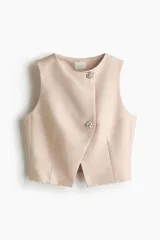 Chaleco corto de sarga en mezcla de algodón, con cuello redondo, frente cruzado asimétrico y cierre con botones joya a presión. Diseño forrado.