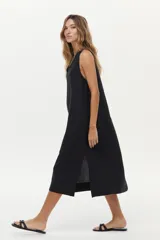 Vestido midi color crudo de corte relajado, con caída fluida, sin mangas y escote en V.