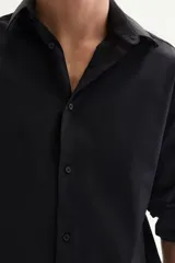 Camisa de corte slim fit en tejido elástico de mezcla de algodón, con cuello italiano, tapeta lisa y mangas largas con puños ajustables. Presenta un bajo levemente redondeado y canesú en la espalda.