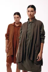 Chaleco de diseño fluido con escote cruzado y lazo ajustable en la cintura. Presenta un corte largo y versátil, ideal para superponer en diferentes looks.