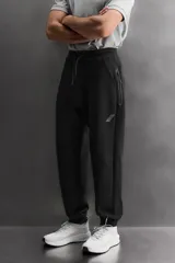 Pantalón jogger de entrenamiento regular fit confeccionado en tejido técnico compacto de algodón con elasticidad y efecto neopreno. Cuenta con cintura elástica ajustable con cordón, bolsillos frontales, un bolsillo lateral con cierre de cremallera y bajo acabado en puño.