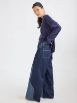 Pantalon ancho de denim en varios tonos de azul con diseño patchwork, de tiro medio y cierre frontal con botones.