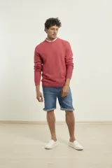 Sweater de punto fino azul con cuello redondo y terminaciones elásticas en canalé.