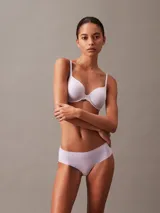 Bombacha tipo hipster de la línea invisible de Calvin Klein, confeccionada en microfibra ligera con bordes cortados a láser sin costuras. Presenta un diseño de talle bajo con cobertura total en la parte trasera y el logo de la marca estampado en la cadera.