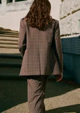 Chaqueta de corte recto estilo sastre con estampado de cuadros. Presenta cuello con solapas de muesca, hombreras, cierre frontal con botones, bolsillos laterales con solapa y bolsillo de ribete en el pecho. Incluye forro interior y abertura posterior en el bajo.