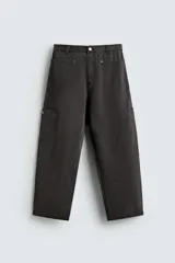 Pantalón de corte relaxed fit confeccionado en algodón, color gris oscuro. Presenta bolsillos delanteros, bolsillos laterales tipo cargo en las perneras y cierre frontal con cremallera y botón.