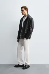 Blazer de corte relajado confeccionado en piel genuina, con cuello de solapas de muesca, manga larga y cierre frontal de tres botones. Presenta bolsillos de vivo en la cadera y un bolsillo interior.