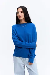 Sweater de punto color azul, con cuello redondo, manga larga y costura central vertical frontal. Presenta un calce relajado con terminaciones acanaladas en puños y ruedo.
