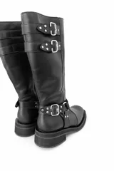 Bota alta de cuero negro con caña alta y hebillas plateadas.