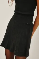 Falda mini tejida de corte acampanado con cintura ancha elástica y acabado brillante con hilos metalizados.