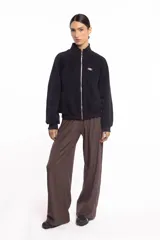 Campera negra de cuello alto con cierre frontal metálico completo, bolsillos laterales y logo bordado en el pecho.