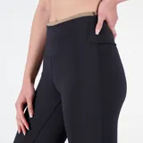 Pantalón deportivo New Balance de dama, modelo Achiever Shape Shield Flare, color negro. Confeccionado con tecnología NB DRYx de secado rápido y tejido Shape Shield que absorbe la humedad. Diseño de tiro alto y silueta ajustada.