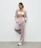 Pantalón deportivo de corte recto confeccionado en plush, con cintura elástica y detalle de costura vertical frontal. Presenta un diseño cómodo y funcional con acabado suave.