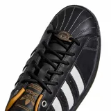 Championes Adidas Superstar II, color negro con las tres tiras blancas características, detalles en dorado y suela de goma marrón.